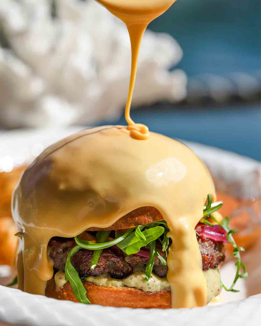 Gourmet burger with cheese sauce at Fish& restaurant in Seychelles