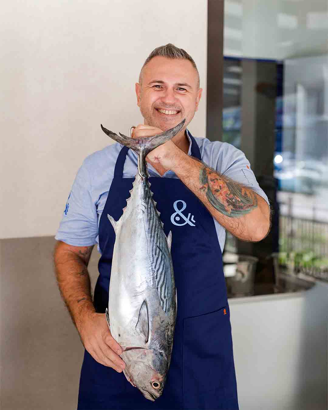 Chef Yuri holding fresh tuna at Fish& restaurant on Eden Island, Seychelles