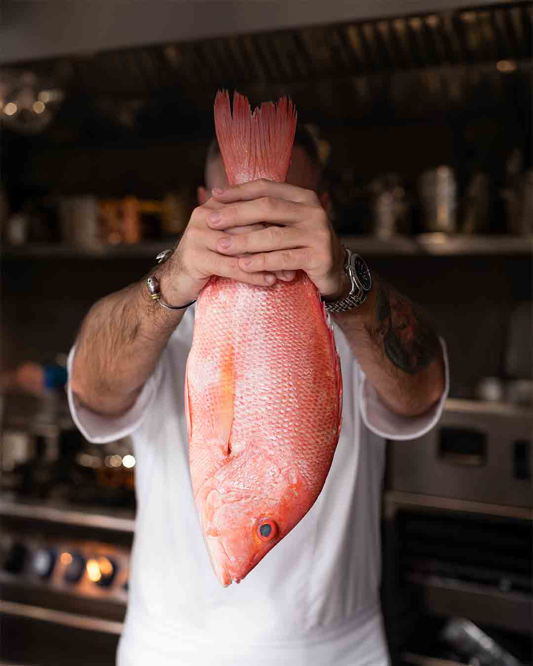 Chef Yuri holding fresh tuna at Fish& restaurant on Eden Island, Seychelles